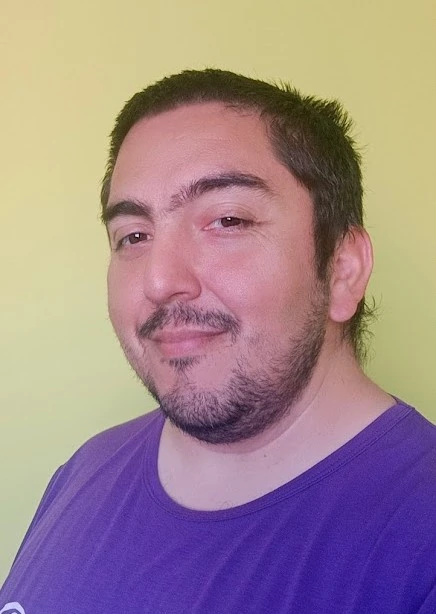 Felix Pacheco, con una remera morada y un fondo de color verde claro